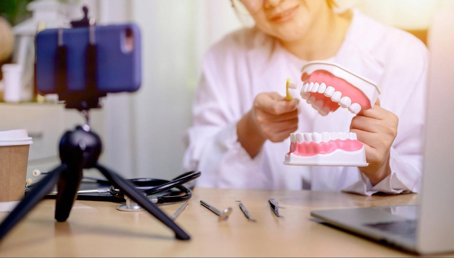 Dental trainee practicing brushing technique on a jaw model in a preclinical lab